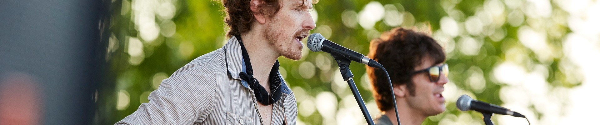 Two men singing into microphones