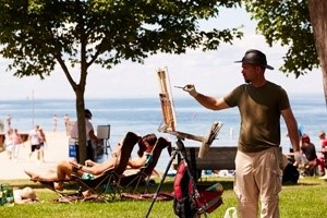 A man painting at the waterfront