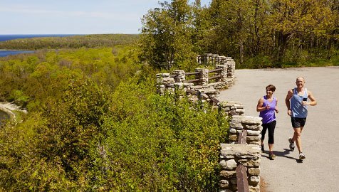 A couple running on an overlook of the lake.