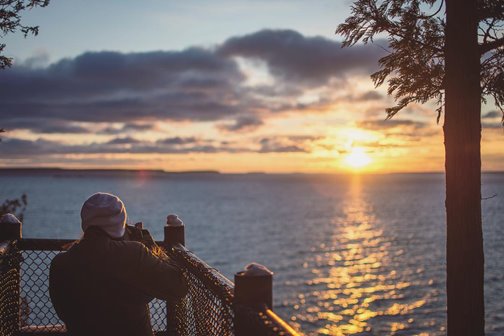 A person at a lookout looking out at the lake.