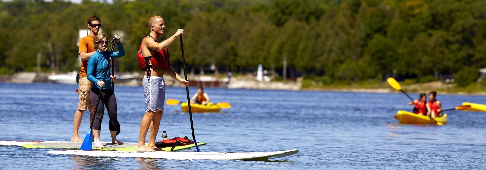 Standup paddleboarders and kayakers enjoying a day out on the water.