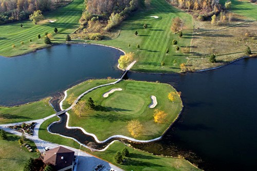 Aerial view of a bright green fairway among ponds.