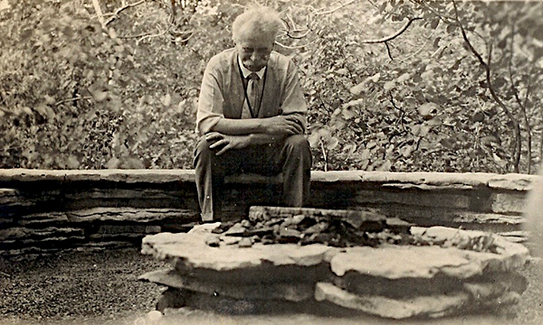 Jensen sits on a stone bench surrounded by nature.