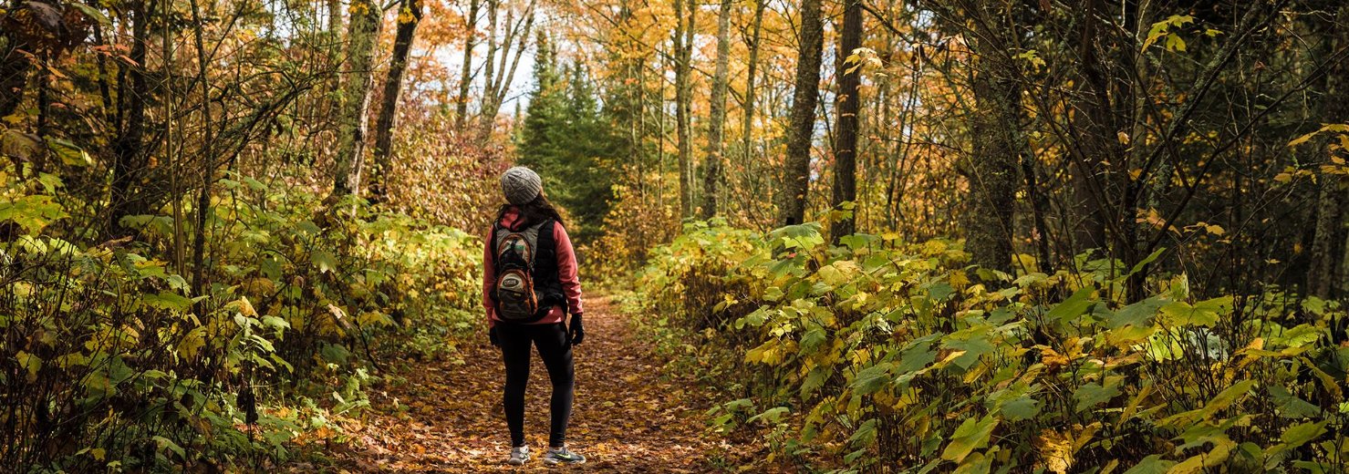 A woman hiking through the woods.
