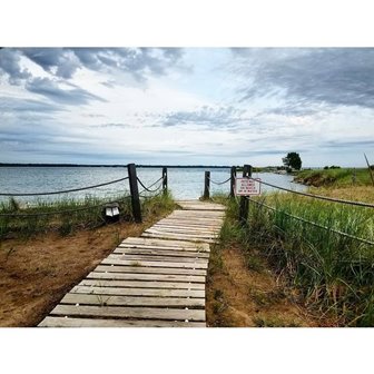 A wooden walkway leading to the lake.