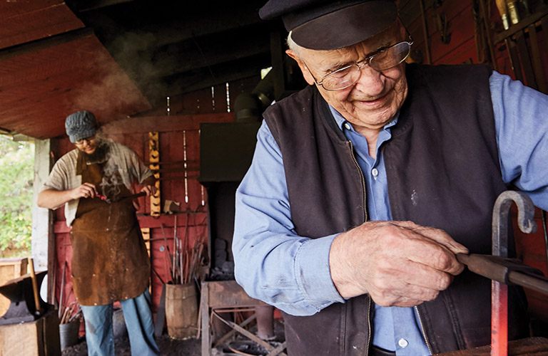 Two blacksmiths working with metal.