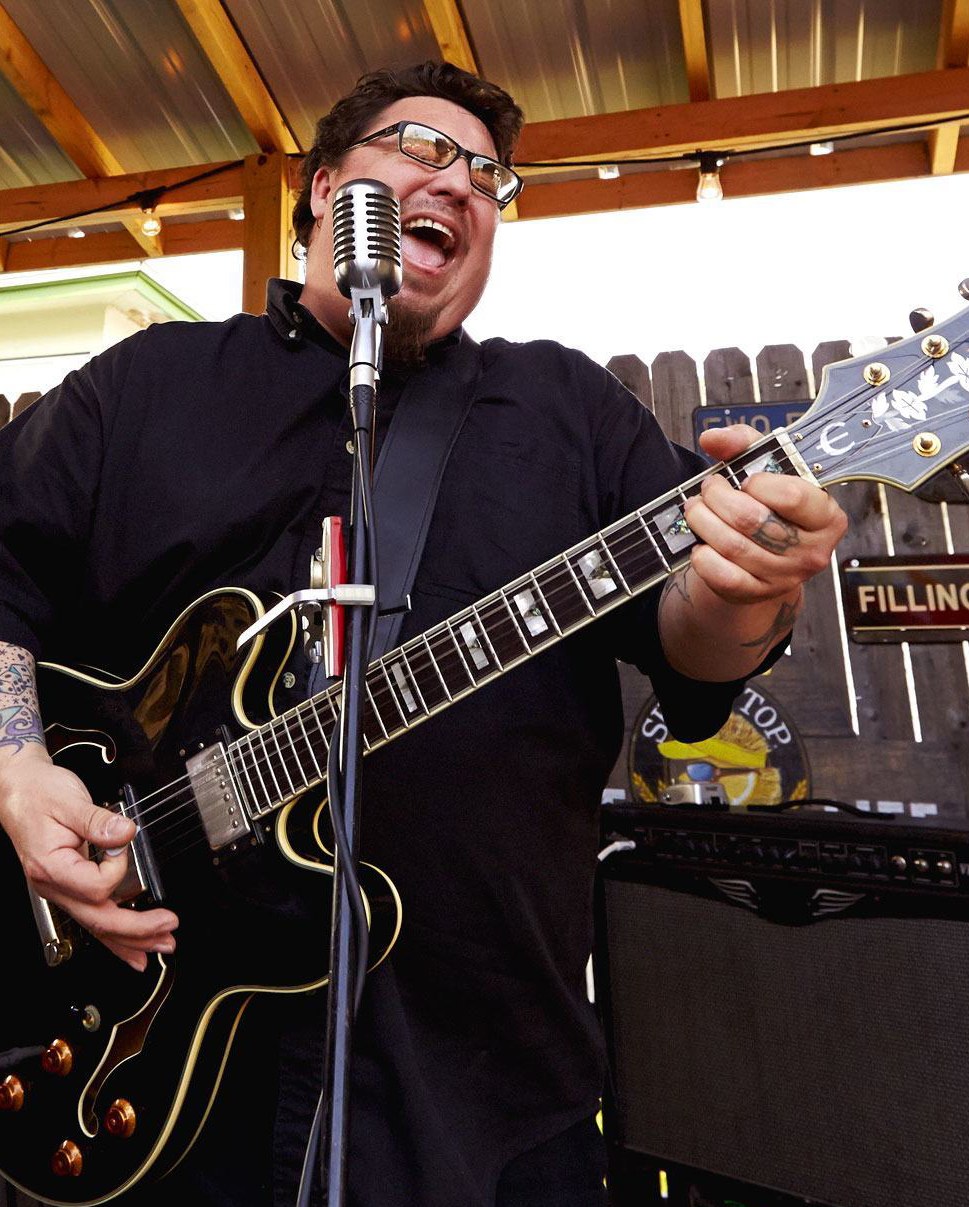 A man playing electric guitar and singing