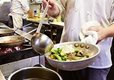 A closeup of a chef cooking in a pan