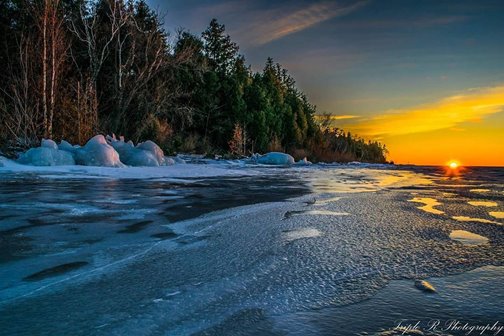 The sun rising over the shoreline.